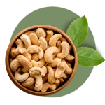 Sri Lanka Cashew Nuts in a clay bown with Cashew leaves in the background.